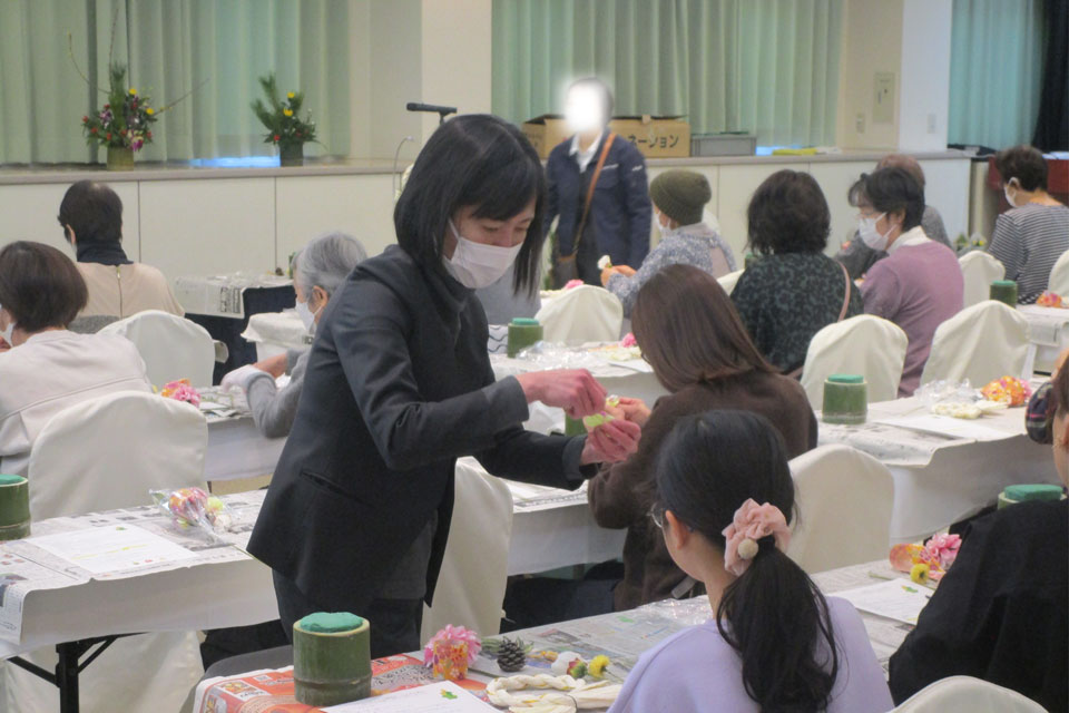 仙台市の葬儀社花さいだんのスタッフが丁寧にフラワーアレンジメントを教えている様子